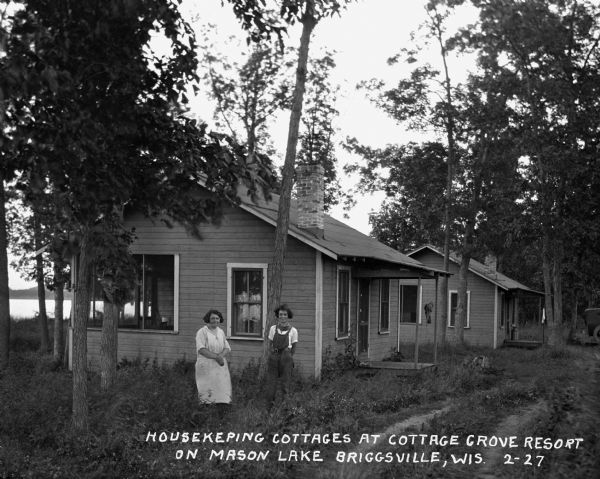Two women pose outside their lakefront cabin.
