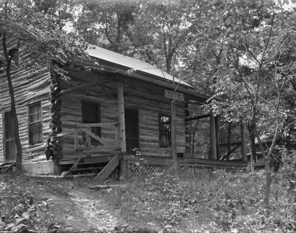 View uphill of a log house with a "Davis Junction" sign on the porch.