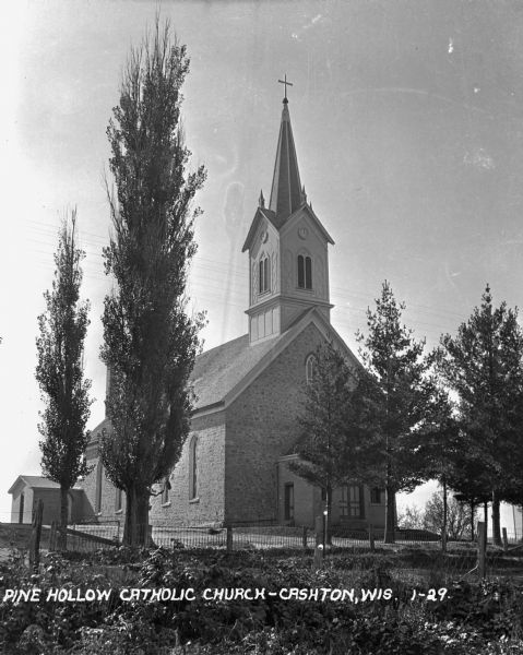 The church features a gable roof, a steeple with clock faces, and a cross on top. Caption reads: "Pine Hollow Catholic Church — Cashton, Wis."