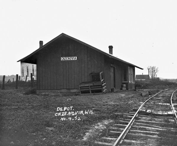 Exterior of the depot and railroad tracks. The depot has a "Cazenovia" sign.