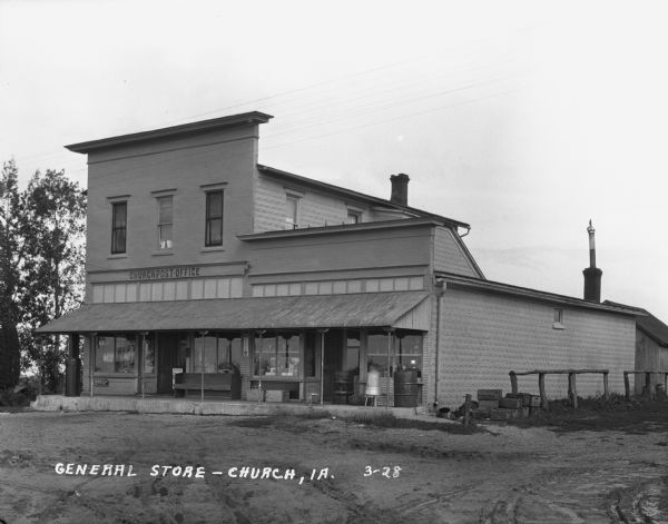 Exterior view of the Church Post Office and general store. Signs painted on the window say: "Hardware, Paints, Oils."