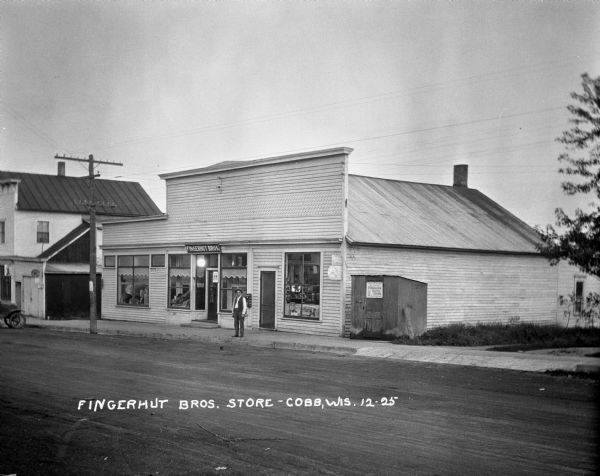 A man poses outside the Fingerhut Brothers grocery and general store.