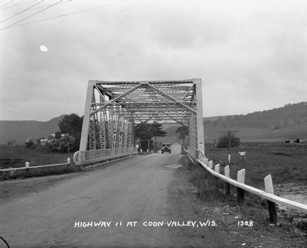 A car drives across a metal bridge on Highway 11.