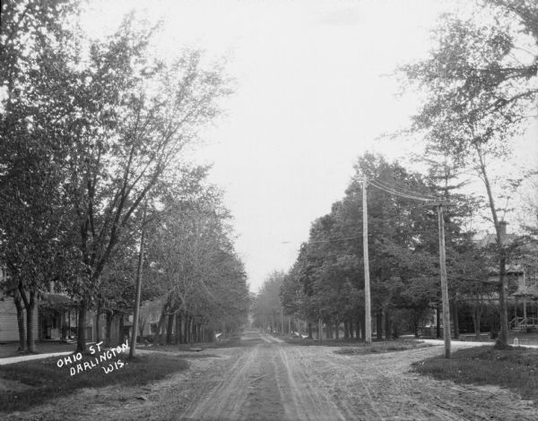 View down the unpaved Ohio Street, with houses on both sides.
