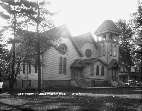 A well-dressed man poses in front of the Methodist Episcopal Church on Park Place.