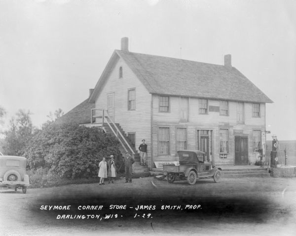 Exterior view of a general store and gas station operated by James Smith. Four people stand posed in front of the building.