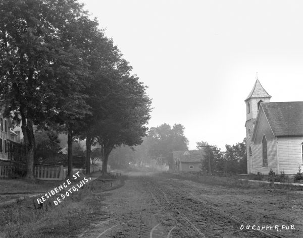 View down unpaved residential road. The Methodist Episcopal Church is on the right.