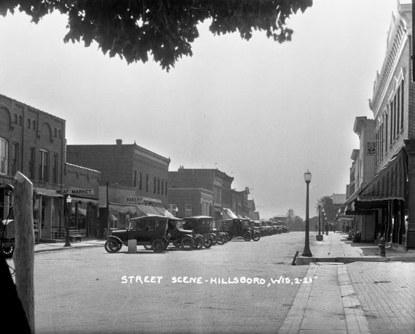 Commercial street in Hillsboro. A row of cars are parked in the center of the street.