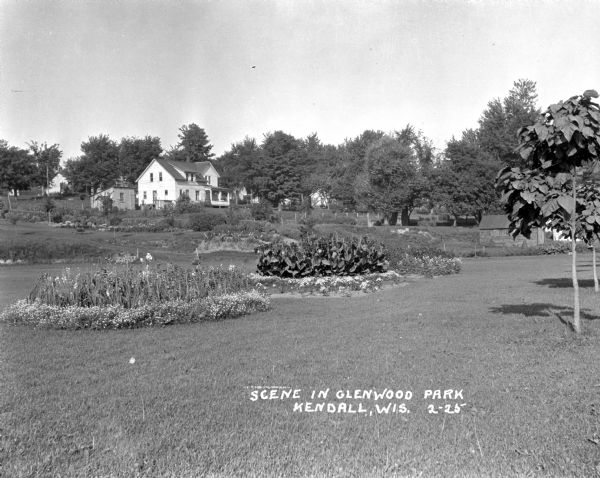 Gardens and flower patches at the Glenwood Park. There is a large building in the background.