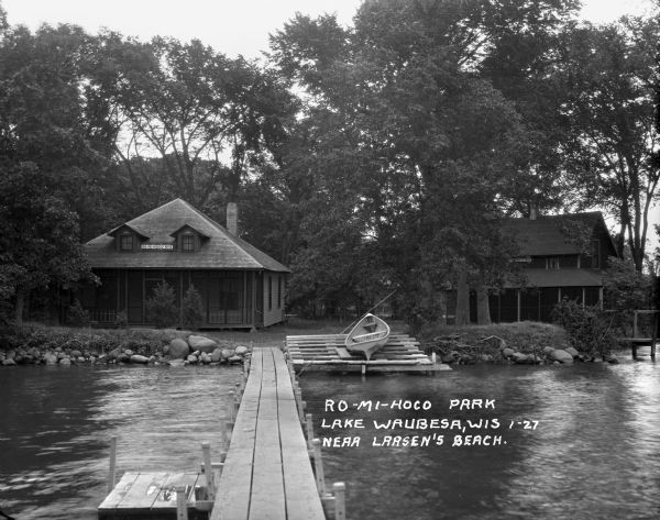 View from the dock looking at a beached canoe and two housing structures at Ro-Mi-Moco Park.