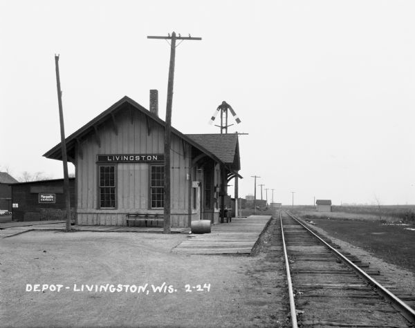 Exterior of the Livingston train depot. A building behind the depot displays a "Marquette Cement" sign.