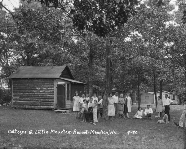 A group of men and women pose on the lawn outside their cottages at the Little Mountain Resort.