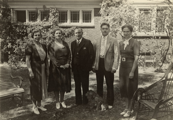 Outdoor group portrait of the Henry Elston Family of Muscoda, with a dog sitting in the foreground. According to US censuses they are from left to right: Marjorie, Laura, Henry, Asaph Clayton (A.C.) and Ruth.