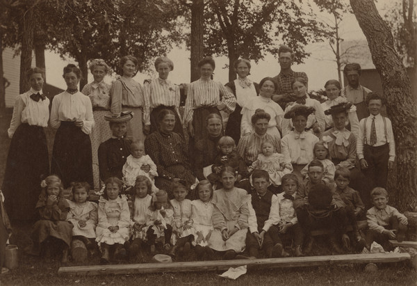 Group portrait of a Muscoda Public School picnic. Emma Schmitt (later Mrs. Sherwin Gillett) is on the far left of the top row. The 1905 Wisconsin Census has Emma listed as a school teacher. The frame has the S. Gillett imprint, but the photograph is from the year before they married.