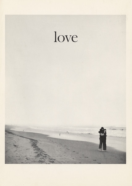 Black and white photographic greeting card. View down beach towards couple hugging while standing in the sand. The word "love" is centered at the top.
