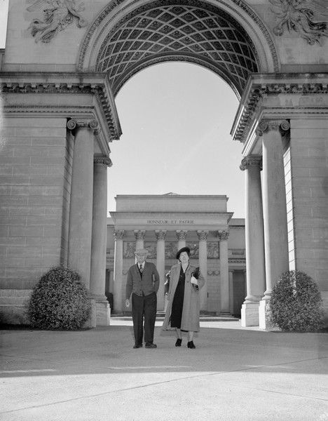Outdoor portrait of Sherwin and Emma Gillett standing under the arch at the Legion of Honor. The museum facade is in the background.