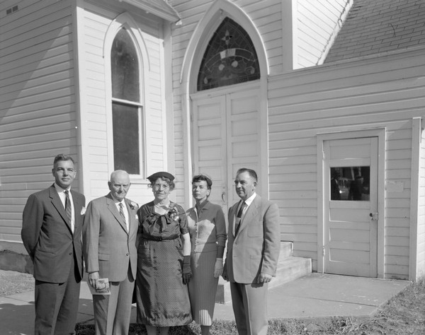 Outdoor portrait of Sherwin and Emma Gillett standing outside the church with their children, Lorin, Sherry and Harry on the occasion of their 50th Wedding Anniversary.