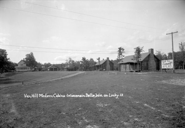 View of a row of cabins on the right. A drive leads to the main building of Van Hill Modern Cabins in the background on the left.