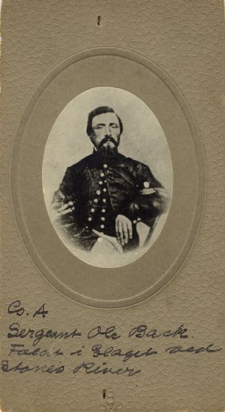 Waist-up seated oval studio portrait of Ole Back, a sergeant in Company A, 15th Wisconsin Infantry, in uniform. The following information was obtained from the Regimental and Descriptive Rolls, Volume 20: He resided in Chicago, Illinois. On October 11, 1861, he enlisted and was eventually mustered into service in Madison, Wisconsin on November 15, 1861. During the Battle of Stone River in Tennessee, Ole Back was severely wounded and was initially sent to a hospital in Nashville, Tennessee, but was eventually sent to another facility near Murfreesboro, Tennessee where he died on January 16, 1863, of the wounds received.