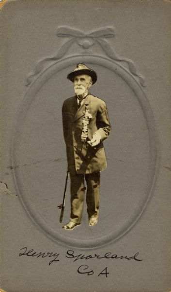 Full-length portrait of Henry Sporland, a private in Company A, 15th Wisconsin Infantry, wearing a double breasted suite and hat with the lettering of G.A.R. (Grand Army of the Republic) on the crown.  The following information was obtained from the Regimental and Descriptive Rolls, Volume 20: He resided in Chicago, Illinois. On October 11, 1861, he enlisted and was eventually mustered into service in Madison, Wisconsin on November 15, 1861, at the age of 29.  The roster does not state that he received wounds, but from September 1862 to July 1864, he was absent-sick at Bowling Green, Kentucky.  He was then transferred to the Veterans Reserve Corps (V.R.C) [also known as the Invalid Corps] on August 15, 1864, by order of Major General George Henry Thomas.