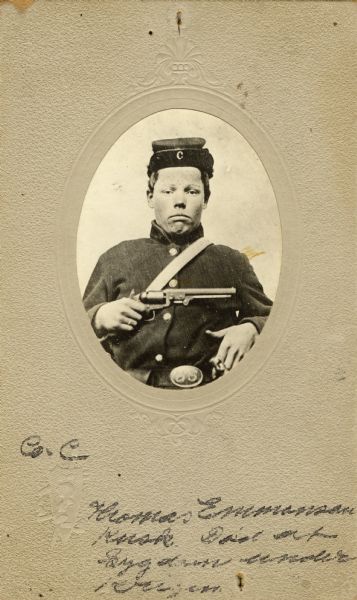 Waist-up oval studio portrait of Thomas Emmonson, a private in Company C, 15th Wisconsin Infantry in uniform and wearing a kepi [forage cap] displaying a “C” on the underside of the brim. He is holding a revolver across his chest. The following information was obtained from the Regimental and Descriptive Rolls, Volume 20: He resided in Norway, Wisconsin. On March 14, 1862, he enlisted in Milwaukee, Wisconsin and mustered into service in Madison, Wisconsin on December 02, 1861, at the age of 21. He served as a teamster in supply trains and served in the Division Quarter Master Department. He died of disease on October 5, 1865, and was removed from the muster rolls on October 19, 1865.