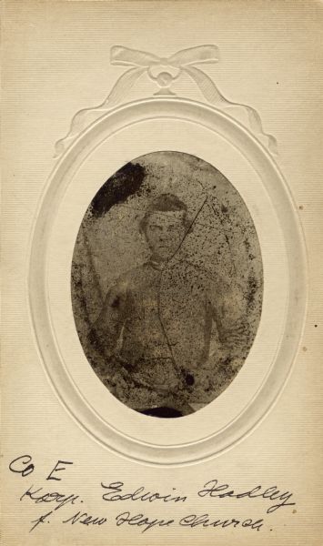 Waist-up oval studio portrait of Edwin Hadley, a corporal in Company E, 15th Wisconsin, in uniform. The following information was obtained from the Regimental and Descriptive Rolls, Volume 20: He resided in Perry, Wisconsin. On January 11, 1862, he enlisted in Dane County, Wisconsin and was mustered into service in Madison, Wisconsin on May 5, 1862, at the age of 19. In December 1862, he was detached briefly to serve as a Provost-Guard. He was killed in action from a gunshot in the head at Altoona Mountain, near New Hope Church, Georgia on May 27, 1864.