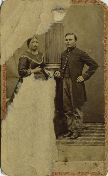 Full-length carte-de-visite portrait of Charles Solar Olson, in uniform, and a woman. He was a private in Company K, 15th Wisconsin Infantry. The following information was obtained from the Regimental and Descriptive Rolls, Volume 20: He resided in (enlistment credited to) Verona, Wisconsin. On January 11, 1864, he enlisted in Madison, Wisconsin and on January 28, 1864, he was mustered into service in Madison, Wisconsin at the age of 26. He was recruited and joined Company K on March 31, 1864, at Strawberry Plains, Tennessee.  On May 27, 1864, he was wounded slightly in the leg during the fighting near New Hope Church, Georgia. On December 20, 1864, he was transferred to the 2nd Battalion, Veteran Reserve Corps by order of the Secretary of War. He was mustered out of service on September 18, 1865, in Davenport, Iowa.