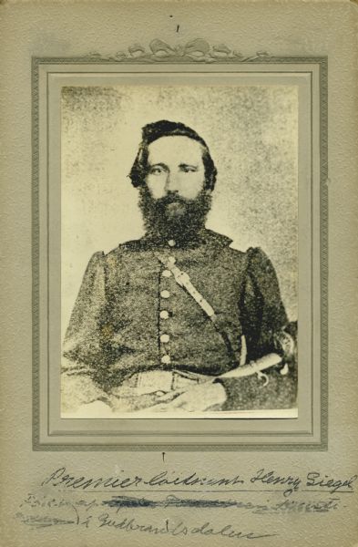 Waist-up seated studio portrait of Henry Siegel, a captain in Company A, 15th Wisconsin Infantry, in uniform, holding a sword across his lap. The following information was obtained from the Regimental and Descriptive Rolls, Volume 20: He resided in Chicago, Illinois. On September 27, 1861, he was enlisted as a first sergeant and mustered into service on November 15, 1861, in Madison, Wisconsin. On September 22, 1862, he was detached from the company to serve as the brigade commissary sergeant. On September 16, 1862, he was promoted to first lieutenant. On October 13, 1863, he was place in charge of a supply train to Stevenson, Alabama. On October 19, 1864, he was commissioned a captain. He mustered out with the company on December 20, 1864, at Chattanooga, Tennessee.