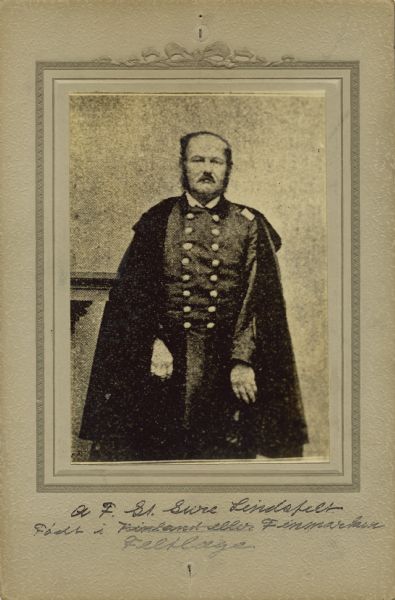 Three-quarter length studio portrait of Adolf F. St. Sure Lindsfelt, a surgeon in the 15th Wisconsin Infantry, in uniform. The following information was obtained from the Regimental and Descriptive Rolls, Volume 20 and 7: He resided in Sheboygan, Wisconsin. On September 28, 1861, he was commissioned as second assistant surgeon and mustered into service on November 18, 1862, in Louisville, Kentucky with the 12th Wisconsin Infantry. Because each regiment was limited to have one surgeon and one assistant surgeon, he was mustered out of 12th Wisconsin Infantry shortly after being entered in on the muster rolls. He was promoted to surgeon on May 26, 1862, and transferred to be the surgeon attached with the Wisconsin 8th Light Artillery Battery. He reported for duty with the Wisconsin 8th Light Artillery Battery on June 6, 1863, and was detached to serve as the surgeon in charge of the Union hospital at Bardstown, Kentucky. On February 20, 1864, he joined the Wisconsin 15th Infantry. On August 15, 1864 he was detached to serve as the brigade surgeon.