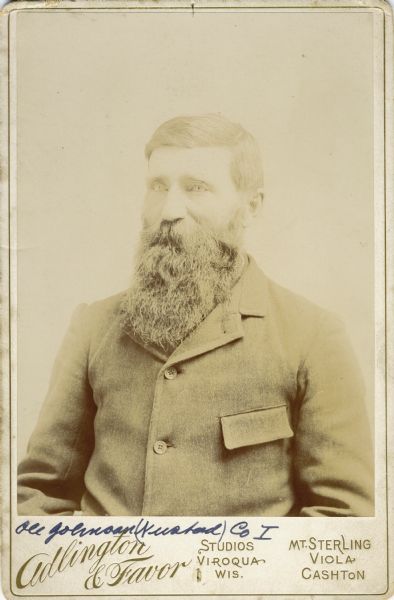 Waist-up cabinet card portrait of Ole Nustad Johnson [as written on the photograph backing; also written as Ole Johnson on Descriptive Rolls, Volume 20, published rosters: Rosters of Wisconsin Volunteers, Volume 1 (1886) and Wisconsin Volunteers (1914)], a private in Company I, 15th Wisconsin Infantry. The following information was obtained from the Regimental and Descriptive Rolls, Volume 20: He resided in Waushara County, Wisconsin. On November 4, 1861, he enlisted in Scandinavia, Wisconsin and on December 12, 1861, he was mustered into service in Madison, Wisconsin at the age of 20. He was mustered out of service on February 10, 1865, at Chattanooga, Tennessee.