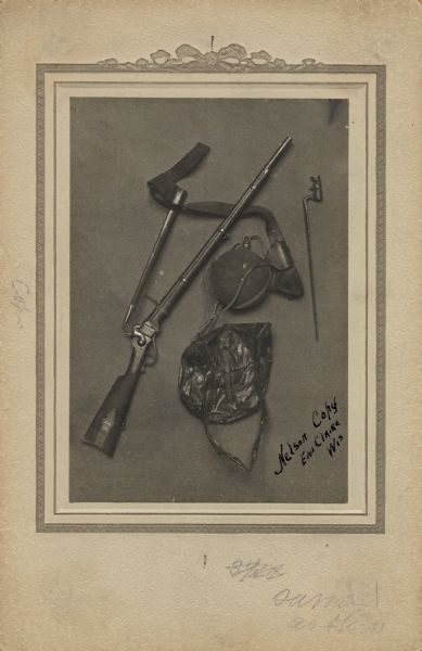 Overhead view of a musket, canteen, scabbard, and bayonet.