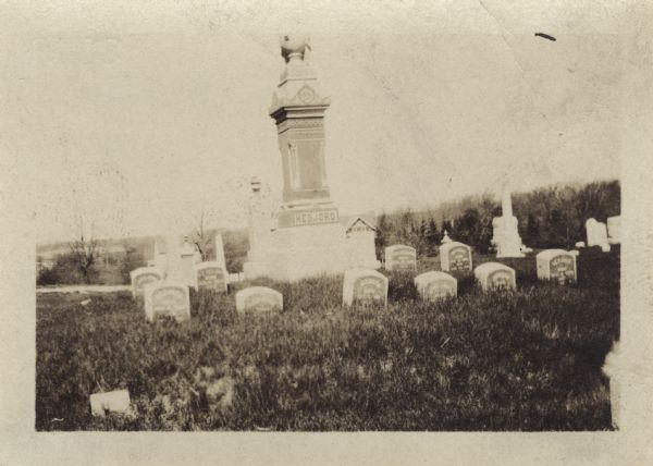 Ten graves of the Hedjord family in the Muskego churchyard. There is an obelisk is the center of graves.