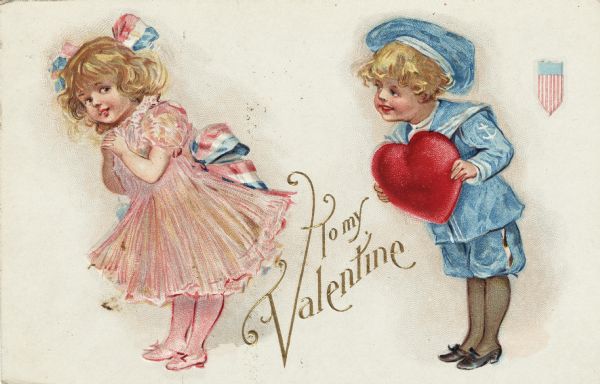 Valentine's Day postcard featuring a girl and a boy. The girl, wearing a pink dress, stockings and shoes, with a red, white and blue sash and hair ribbon, is leaning forward while glancing back shyly. The boy, wearing a blue and white sailor suit, leans towards her while holding a large red heart. In the upper right corner is the federal shield of the United States. Between the children is the text: "To My Valentine". Chromolithograph, embossed.