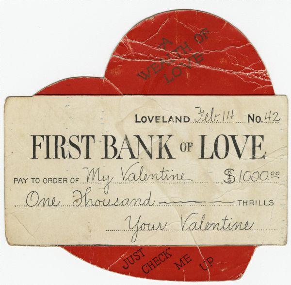 Valentine's Day card of a large heart with a "check" on top of it. At the top of the heart is the text: "A Wealth of Love," and at the bottom is: "Just Check Me Up." On the check it reads: " Loveland...Feb. 14...No. 42. FIRST BANK of LOVE. Pay to the Order of My Valentine, $1000.00, One Thousand Thrills, Your Valentine." Letterpress and die cut.