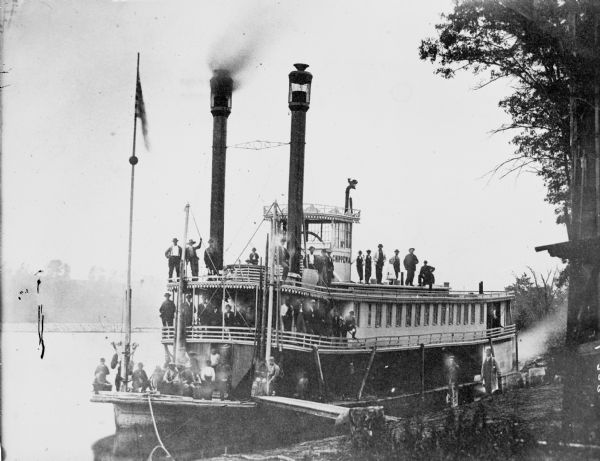 The river steamer <i>Chippewa</i> drawn up alongside shore on the West Eau Claire Levee. The steamer was built by Captain E.E. Heerman at La Crosse in 1866. Used mainly between Eau Claire and Read's Landing, Minnesota. It was destroyed by fire while in winter quarters at Rumsey's Landing on the Chippewa River in 1871. Men and children are standing on all three of the decks.