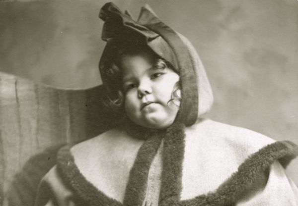 Quarter-length portrait of Margery Bish, the young daughter of the photographer, wearing a heavy hooded coat.