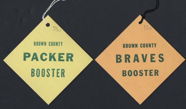 Two two-sided booster tags, one featuring "Brown County Packer Booster" and the other (which is featured on the reverse of the Packer tag, and vice versa) "Brown County Braves Booster."