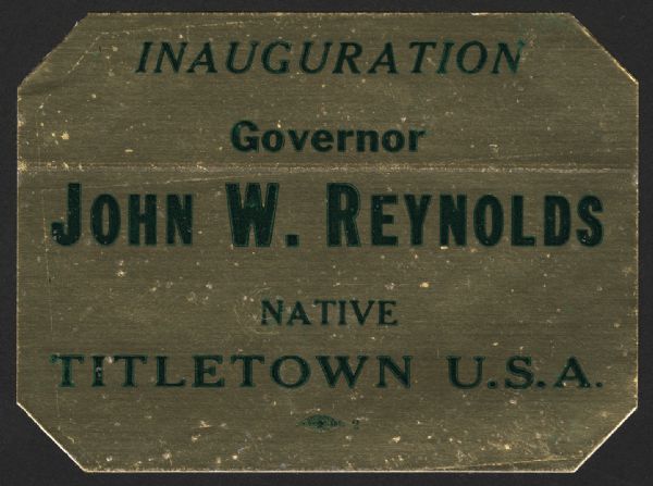 A shiny sticker for the inauguration of Wisconsin Governor John W. Reynolds (4/4/1921 – 1/6/2002), Jr. that highlights his status as a native of "Titletown U.S.A."