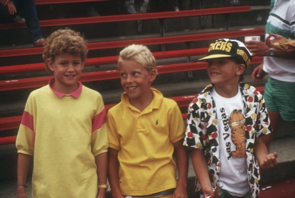 Three young boys in bleachers during a preseason Green Bay Packers game against the Washington Redskins at Camp Randall Stadium in Madison, WI. The Packers lost 0 to 33.