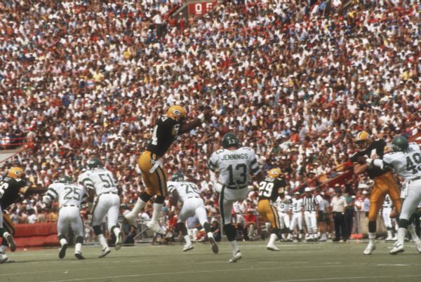 Gren Bay Packer Mossy Cade (#24) blocking a punt by the New York Jets during a preseason game that took place at Camp Randall Stadium. This was the largest crowd ever to see the Packers play in Wisconsin and the first pro football game ever held in Madison. The Packers won the game 38 to 14.