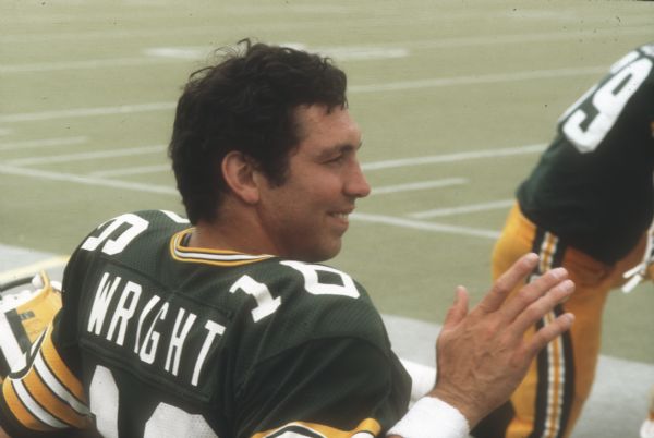 Green Bay Packers quarterback Randy Wright (#16) sitting on the sideline during a preseason game against the New York Jets that took place at Camp Randall Stadium. This was the largest crowd ever to see the Packers play in Wisconsin and the first pro football game ever held in Madison. The Packers won the game 38 to 14.