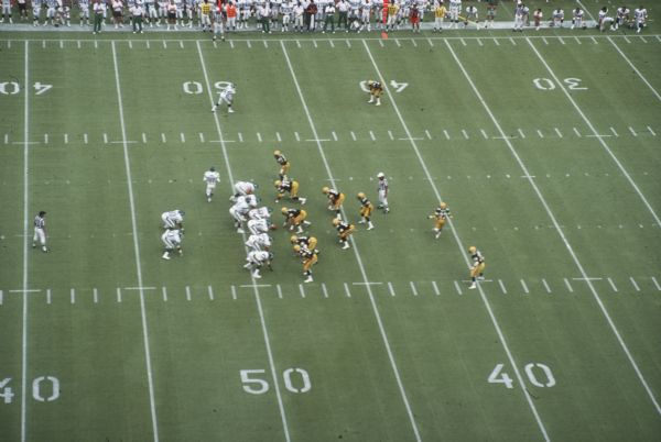 Elevated view of moment right before a play during a pre-season game between the Green Bay Packers and the New York Jets. The game took place at Camp Randall Stadium. This was the largest crowd ever to see the Packers play in Wisconsin and the first pro football game ever held in Madison. The Packers won the game 38 to 14.