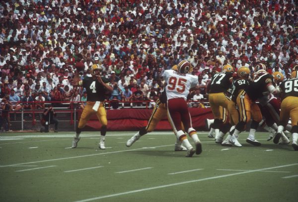 Green Bay Packers quarterback Chuck Fusina (#4) in the middle of a passing play during a preseason game at Camp Randall Stadium against the Washington Redskins. The Packers lost 0 to 33.