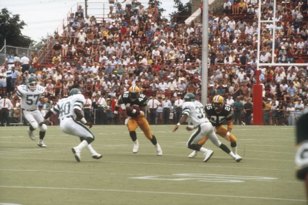 Green Bay Packer's running back Gary Ellerson (#42) mid-play in a preseason game against the New York Jets that took place at Camp Randall Stadium. This was the largest crowd ever to see the Packers play in Wisconsin and the first pro football game ever held in Madison. The Packers won the game 38 to 14.