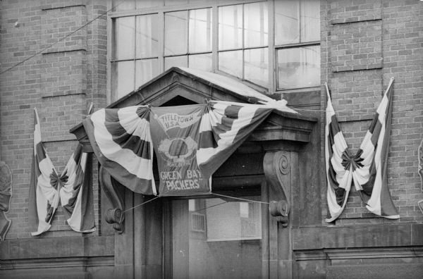 A banner with the text "Titletown U.S.A. Home of the Green Bay Packers" and also an image of Lambeau field over the entrance to a building, very likely Kellogg Bank. The Packers were about to play for, and would go on to win, their seventh title as World Champions of Pro Football.