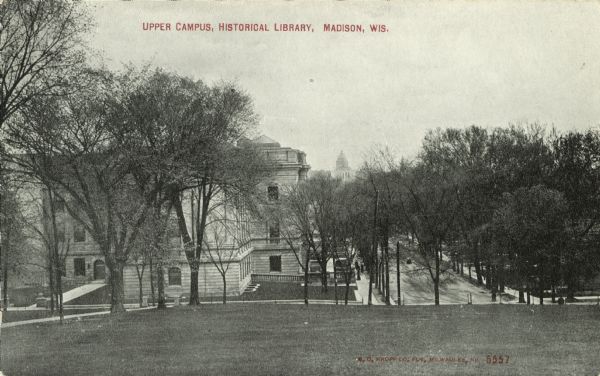 Black and white postcard of the Upper Campus, the west side of the State Historical Library, now the headquarters building of the Wisconsin Historical Society, is on the left. There is a courtyard on the Park Street side of the Historical Library building. State Street extends to the bottom of Bascom Hill. The Wisconsin State Capitol is in the far distance. The text at the top reads: "Upper Campus, Historical Library, Madison, Wis."