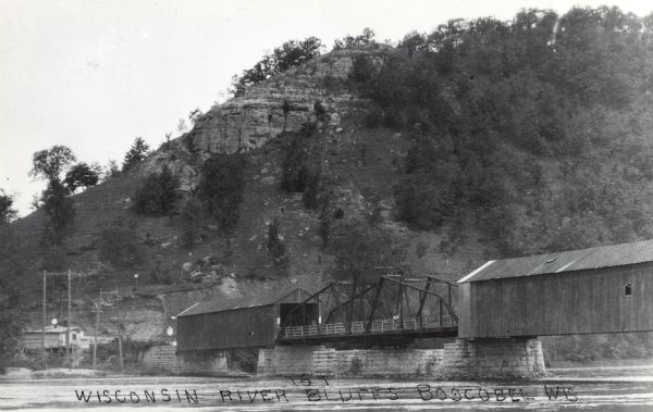 Photographic postcard of the Wisconsin River Bluffs and covered bridge. Text below reads: "Wisconsin River Bluffs, Boscobel, Wis."