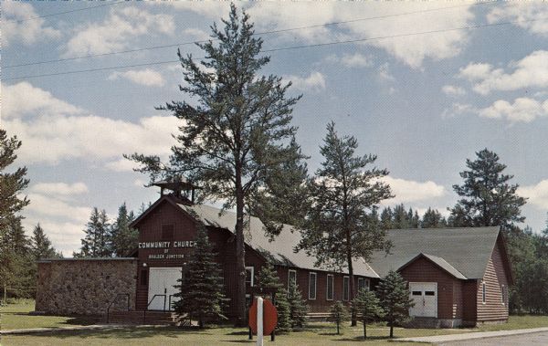 Color postcard of the Community Church with many trees surrounding it.