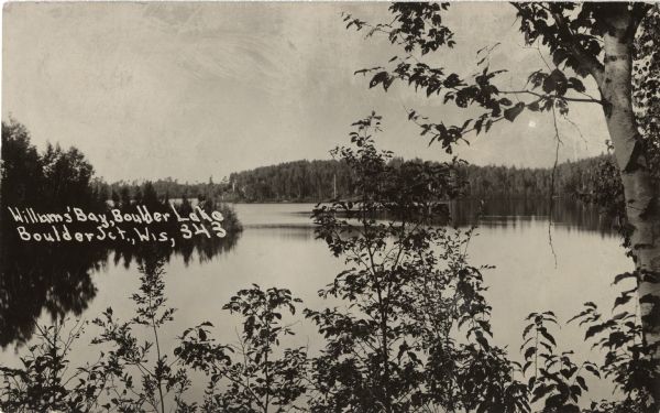 Photographic postcard of Williams' Bay on Boulder Lake. Caption reads: "Williams' Bay, Boulder Lake, Boulder Jct., Wis."