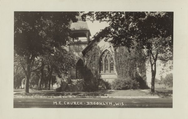 Photographic postcard view of the Methodist Episcopal Church. Caption reads: "M.E. Church, Brooklyn, Wis."
